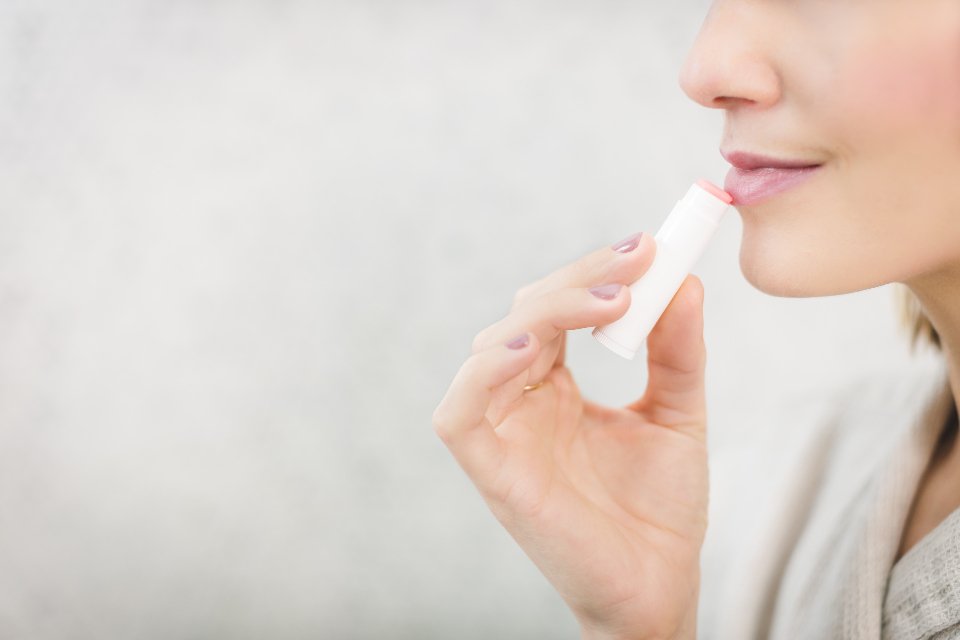 Woman applying lip balm