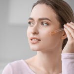 Woman applying retinol serum dropper