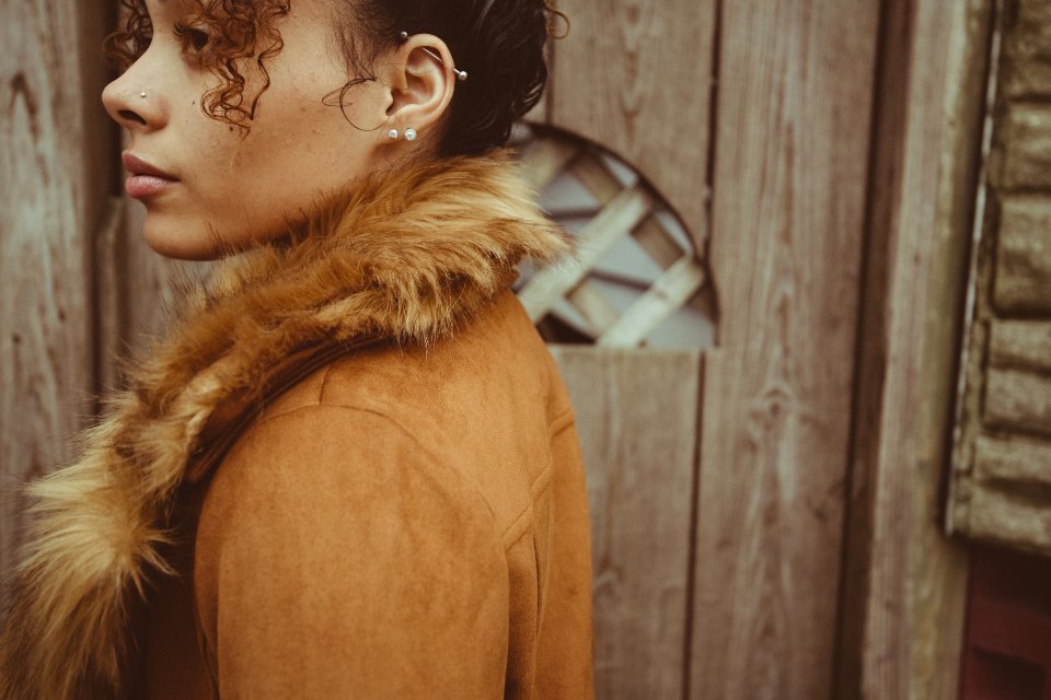 Woman wearing small stud earrings in a profile portrait
