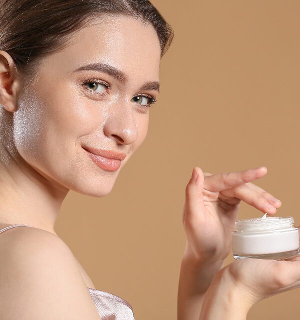Woman holding eye cream jar