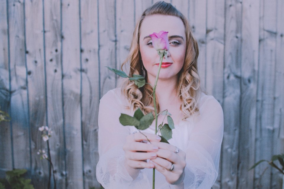 Woman holding a rose, inspired by floral niche perfumes