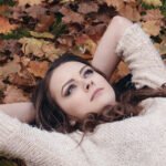 Woman in sweater autumn leaves