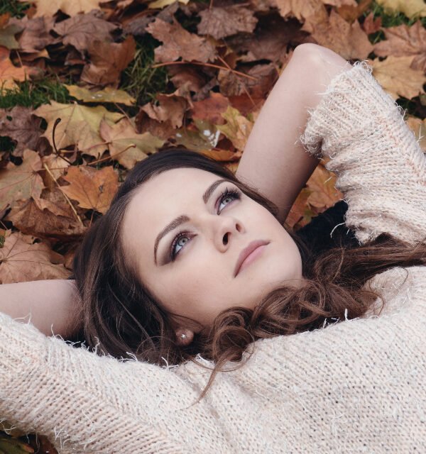 Woman in sweater autumn leaves