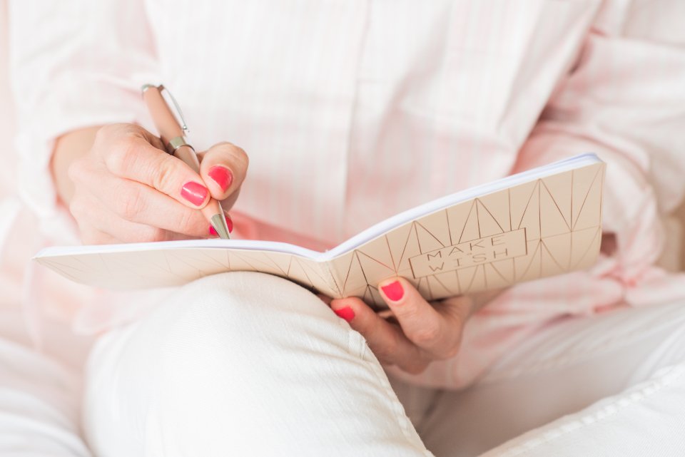 Woman journaling in a notebook after reading the best self help books for women
