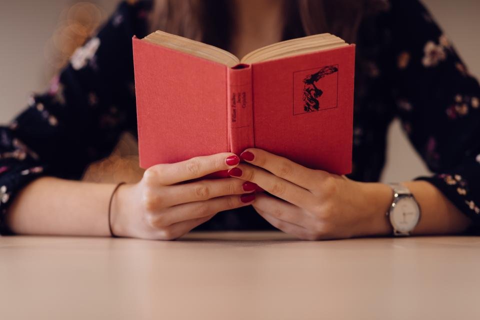 Woman reading a red novel, one of the best book club books