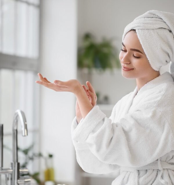 Woman skincare by bathroom window