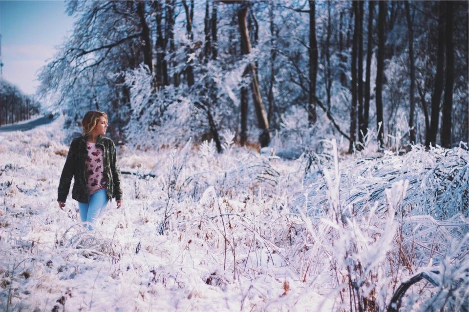 Woman walking through a snowy winter forest