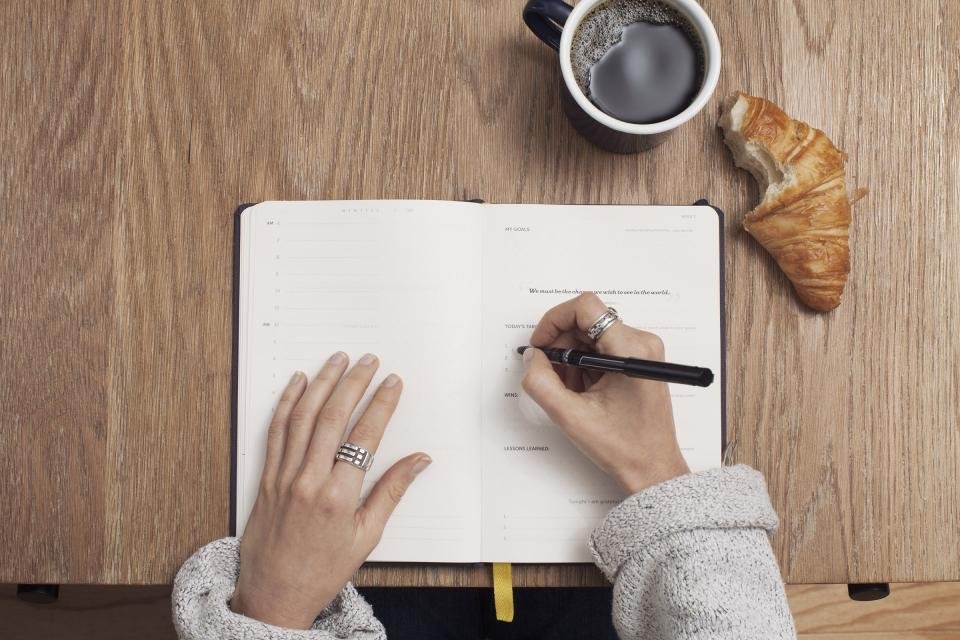 Person writing in a planner, practical gifts for coworkers
